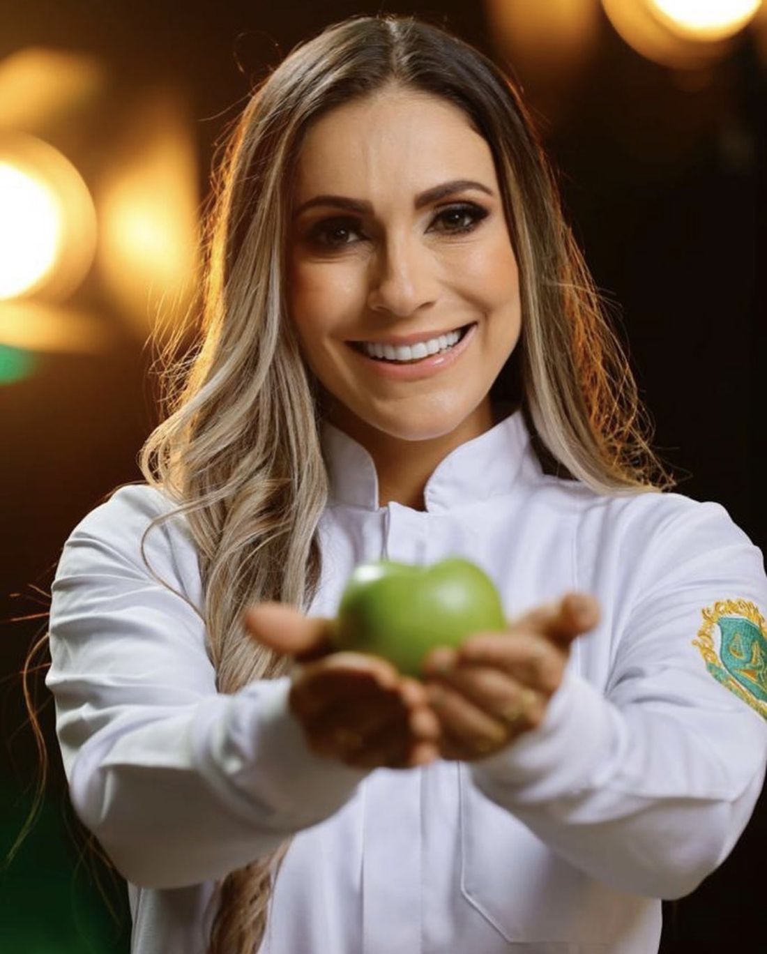 Rafaella Canuto, nutricionista, segurando uma maçã verde